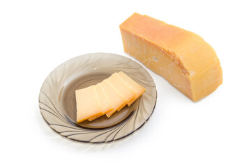 Piece and several slices on saucer of Dutch hard cheese