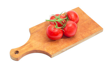Branch of the red tomatoes on the wooden cutting board