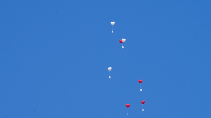 Herz-Ballone am blauen Himmel aufsteigend