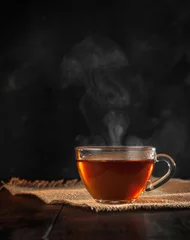 Fototapete Tee Eine Tasse frisch gebrühten schwarzen Tee, Dampf entweichen, warmes weiches Licht, dunklerer Hintergrund.