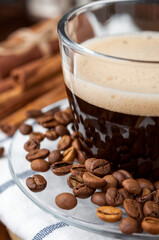 Glass Cup of hot coffee with foam close-up scattered grain,white napkin.