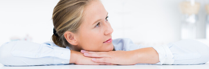 Nachdenkliche blonde Hausfrau