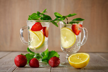 Fresh summer healthy drink with lemon and strawberries with ice.
