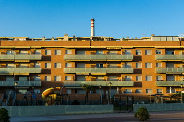 Fototapeta premium Housing at sunset with factory behind