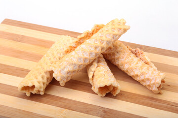 Homemade wafer rolls with powdered sugar isolated on white background