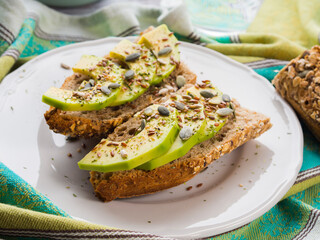 Avocado cereal sandwich for healthy snack with seeds on green napkin