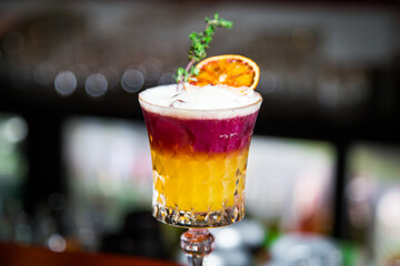 Closeup glass of New York sour cocktail decorated with orange at bar counter background.  Whiskey sour