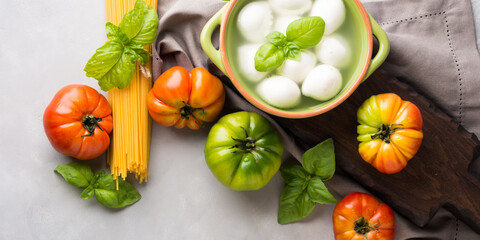 Italian food tomato mozzarella still life on gray rustic background. Traditional products
