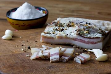 Salted pig fat with spices. Bacon, onion, garlic, spices on a wooden Board.