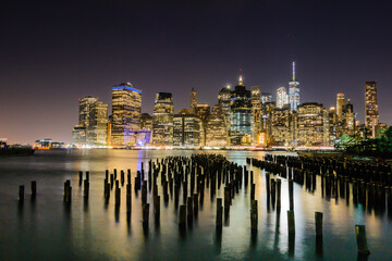 The illuminated Skyline of New York City from the Brooklyn Bridge Park