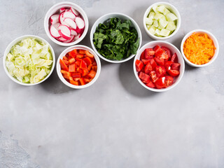 Mix of vegetable bowls for salad or snacks on gray background. Diet detox concept