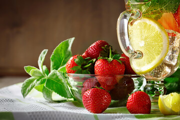 Fresh summer healthy drink with lemon and strawberries with ice.