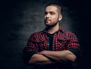 Bearded hipster male with crossed arms over grey background.