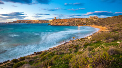 Mgarr, Malta - The famous Ghajn Tuffieha bay at blue hour on a long exposure shot with beautiful sky and clouds