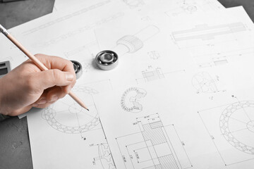 Engineer working with part blueprints on workplace