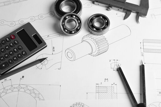 Engineering supplies and part blueprints on workplace