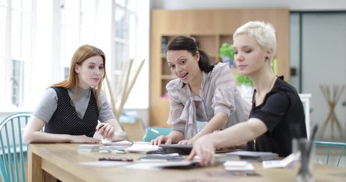 Female designers looking at samples in a meeting