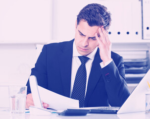 Naklejka premium Worried manager working in office