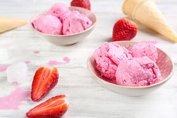 Delicious ice-cream with strawberry in bowls on table