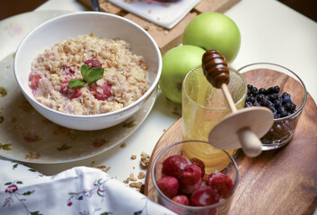 The concept of a healthy Breakfast. Oatmeal with berries, apples and honey.
