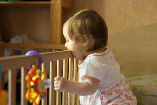 Teething infant is biting railing of cribs