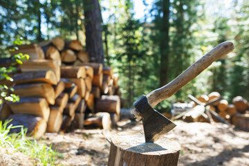 Old axe standing against a piled pieces of firewood