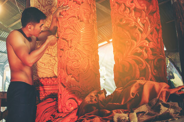 man in traditional Ancient style costume with engraving Tool create the candle sculpture for the...