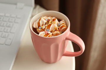 Cup of tasty cocoa drink with marshmallow on table