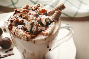 Cup of tasty cocoa drink with marshmallow on table, closeup