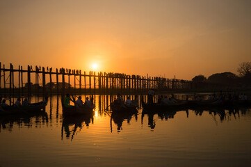 Obraz premium Silhouettes of tourists in boats admiring U Bein bridge over the Taungthaman Lake at sunset, in Amarapura, Mandalay, Myanmar