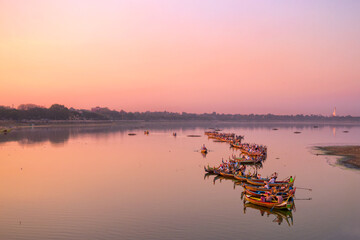 Traditional burmese boats on Taungthaman Lake at sunset, in Amarapura, Mandalay, Myanmar