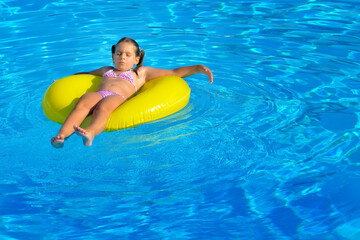 Adorable toddler relaxing in swimming pool