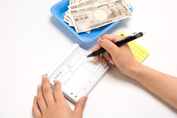 出金伝票を書く経理の女性の手元
