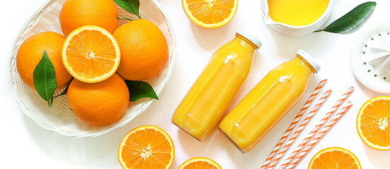 Two glass bottles of fresh orange juice, straws and oranges isolated on white background top view. © VictoriaKurylo