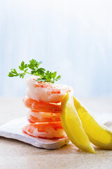 Tiger shrimps with lemon and parsley on black white wooden board. Selective focus, top view, free text space.