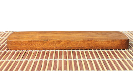 Empty rectangular wooden plate on bamboo mat