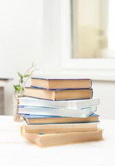 A stack of books on a white table