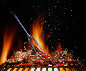 Beef steaks on the grill with flames