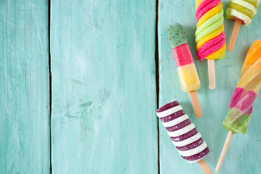 colorful popsicle ice cream on turquoise wooden background