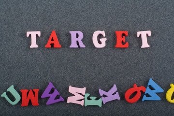 TAREGET word on black board background composed from colorful abc alphabet block wooden letters, copy space for ad text. Learning english concept.