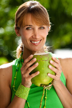portrait d'une femme souriant avec une noix de coco