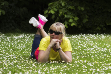 Fototapeta premium 45 years old beautiful woman lying on the ground in nature
