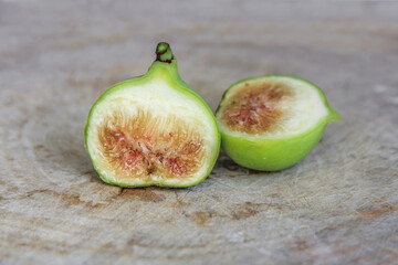 Conadria figs cut through to show the flesh and seeds on wooden background.