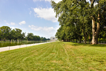 Fototapeta na wymiar Grand view westwards along the ceremonial tree-lined boulevard of the National Mall looking towards the historic Lincoln Memorial, Washington DC