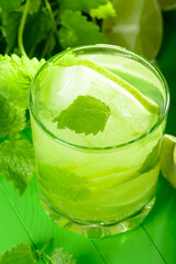 A glass of lemonade with lime and mint