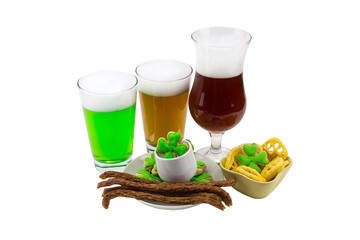 three glasses of beer bamboo unfiltered stout with a variety of snacks and biscuit clover with green mastic. Celebrating St. Patrick's Day