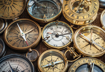 Old compass collection on vintage wood. Exploration and nautical theme grunge background.