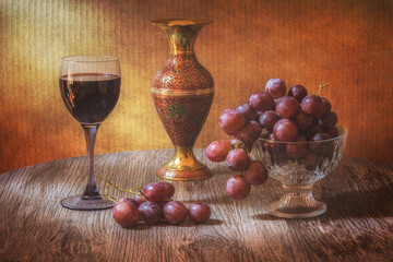 Red wine and red grapes on a wooden table. Still life with grapes and wine.