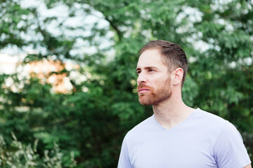 Portrait of a casual bearded man in a park