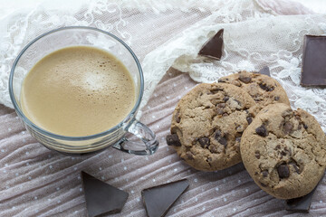 Big cup of espresso with tasty cookies with dark chocolate on the light pink background